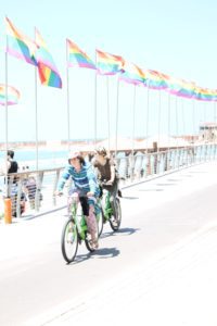 Girls ride bikes along the Tel Aviv Promenade past Hilton Beach, the gay beach. (Photo: Super G)