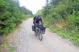 Author, filmmaker and adventurer Dianne Whelan is seen biking through Barachois Brook on Saturday afternoon on the old railroad bed as part of her “500 Days in the Wild” 24,000 km trek across Canada. The adventure will involve hiking, biking and peddling canoe. (Photo: Courtesy of Frank Gale/The Western Star)
