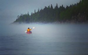 Dianne Whelan paddling across the Lake Superior Water Trail heading toward the fire lit by a friend to help her find her way. (Photo: Courtesy of 500daysinthewild.com)