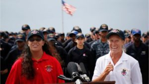 Tasha Fuiava, left, and Jennifer Appel, right, greet reporters with the crew of the USS Ashland behind them at the White Beach Naval Facility in Okinawa, Japan. (Photo: Associated Press)