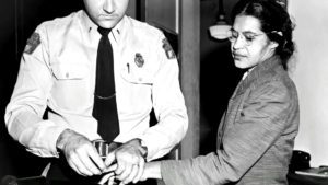 Rosa Parks being arrested for refusing to give up her seat on a bus in 1955.