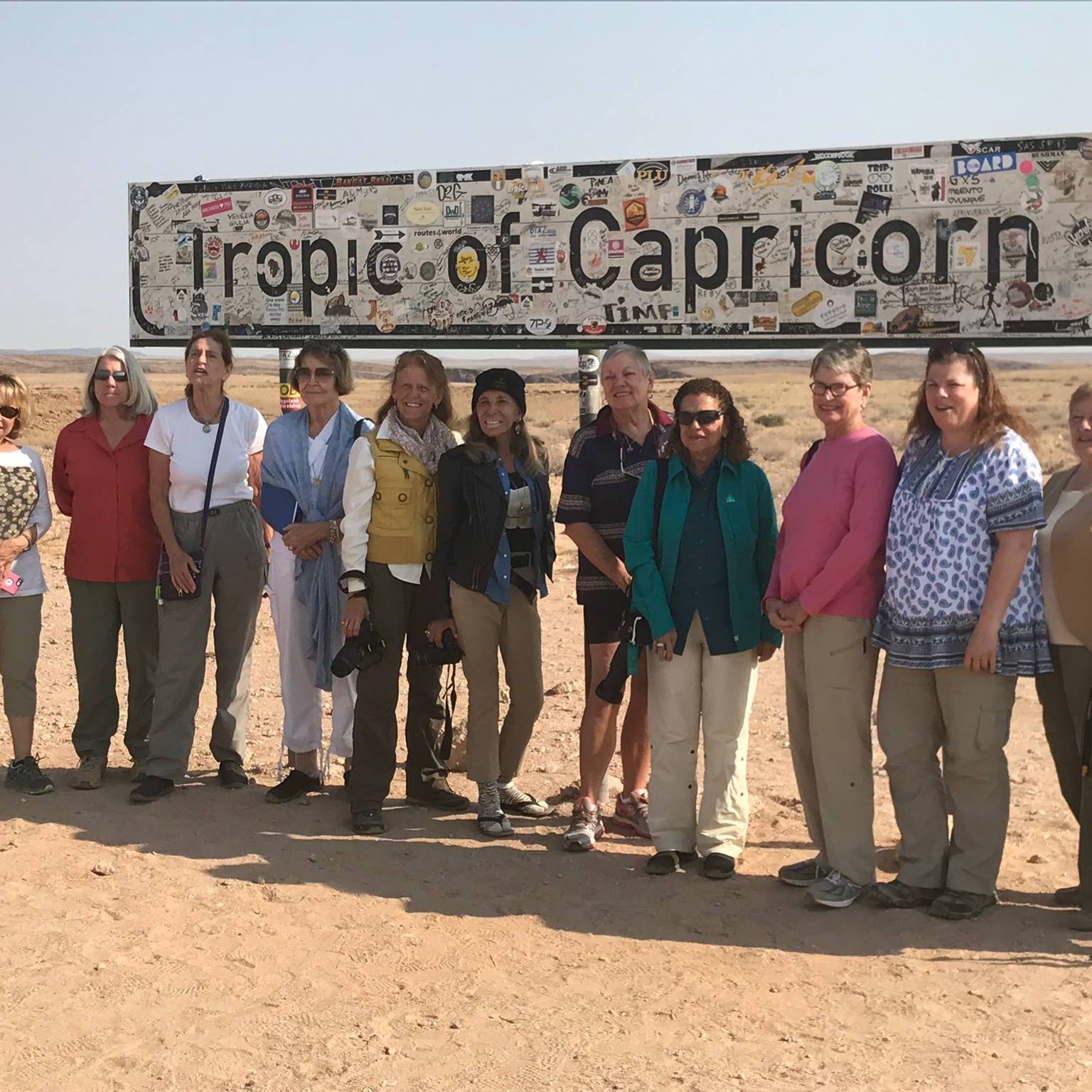 Guests of the Women’s Travel Group take a group photo beneath the “Tropic of Capricorn” sign in Namibia, Africa.