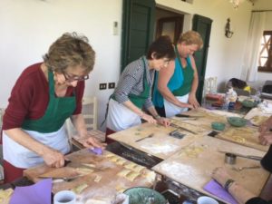 Guests of the Women’s Travel Group making ravioli’s in Tuscany, Italy.