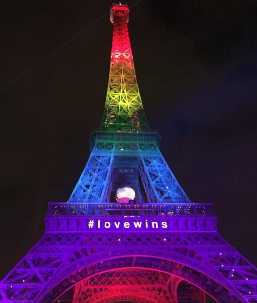 The Eiffel Tower lit up in a rainbow with the message #lovewins
