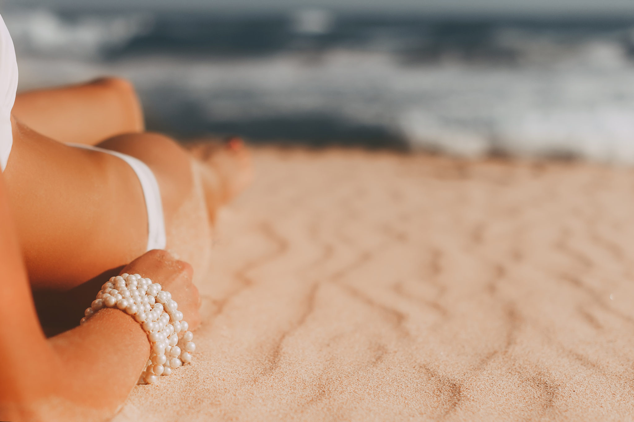 young woman lying on exotic sandy beach