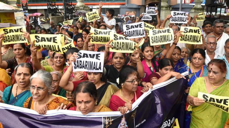 Protestors holding signs “Save Sabarimala” marching in the streets of Kerala, India