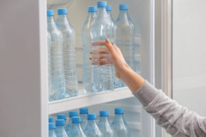 Woman buying plastic water bottle
